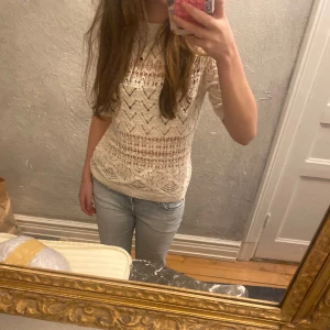 Vit stickad tröja - Säljer en vit stickad tröja med ett fint mönster. Tröjan har trekvartsärmar och en bekväm passform. Perfekt våren och sommaren