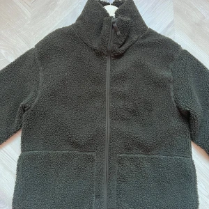 Grön teddyjacka från H&M - Grön teddyjacka från H&M i superfint skick, endast använd 2-3 ggr. Är i storlek L, men skulle säga att den är lite mindre i storleken och passar M också🫶⭐️