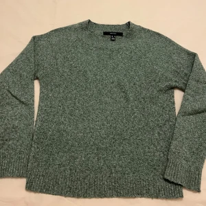 Grön stickad tröja från veromoda  - Mysig grön stickad tröja från veromoda med rund hals och långa ärmar. Perfekt för kyliga dagar med sin mjuka och bekväma passform. Ribbstickade muddar vid ärmslut och nederkant ger en klassisk look. Passar utmärkt till både jeans och kjol.