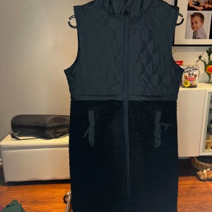 Svart quiltad väst från SOC - Säljer en svart quiltad väst från SOC i storlek XS. Västen har en dragkedja framtill och är perfekt för kyligare dagar. Den har en stilren design med quiltade detaljer och mjukt foder.
