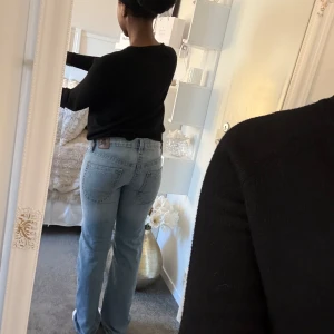 Ljusblå jeansbyxor - Snygga ljusblå jeansbyxor med klassisk femficksdesign. De har en rak passform och är perfekta för en avslappnad stil. Byxorna har en knapp och dragkedja framtill.