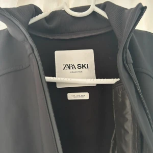 Svart jacka från Zara Ski Collection - Snygg svart jacka från Zara Ski Collection med dragkedja framtill och flera praktiska fickor. Perfekt för kyliga dagar med sin stilrena design och funktionella detaljer.