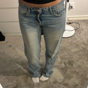 Blå lågmidjade jeans från Weekday - Snygga blå lågmidjade jeans från Weekday i modellen Arrow Low Straight. De har en klassisk femficksdesign och är lågmidjade med en rak passform. Perfekta för en avslappnad stil. Har en pytteliten limfläck på sidan av ena låret men ingenting som syns!