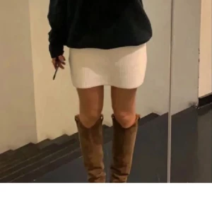 Vit ribbad kjol från Zara  - Snygg vit ribbad kjol i kort modell. Perfekt för att matcha med en oversized tröja eller en tight topp. Kjolen är använd men fortfarande i fint skick! Hör av er för privata bilder. Dessa är lånade!!😍