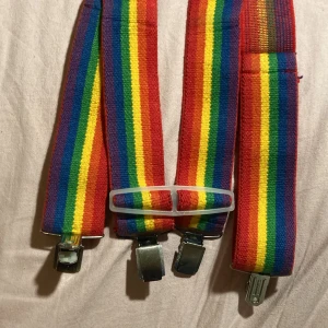 Regnbågsfärgade hängslen - Snygga regnbågsfärgade hängslen med justerbara remmar och metallklämmor. 