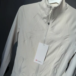 Lululemon jacka - Snygg vit/beige Lululemon define jacket i storlek 6 passar mig som har 36/38 modell:Nulu 