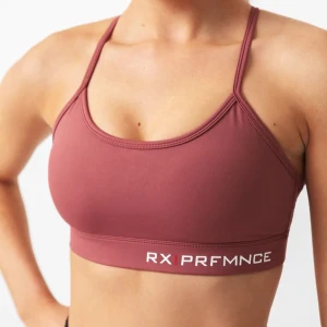 Rosa sport-bh från RX PRFMNCE - Säljer en rosa sport-bh från RX PRFMNCE. Den har smala axelband som korsas i ryggen och ett elastiskt band under bysten med logotypen. Perfekt för träning och ger bra stöd. Materialet är mjukt och stretchigt för maximal komfort. Nypris 399kr