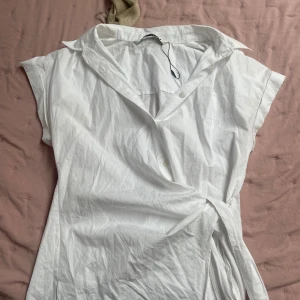 Zara topp - Denna snygga blus från zara som man knyter på sidan av midjan. Bra skick inte mkt använd. 