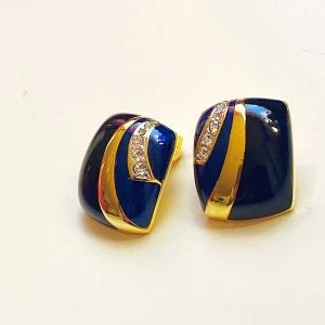 Vintage örhängen med kristalldetaljer - Snygga clipsörhängen i en fyrkantig form med en elegant kombination av blått och guld. De har en glittrig detalj av små kristaller som ger en lyxig känsla. Perfekta för en fest eller en speciell kväll. Klämfäste för enkel användning.