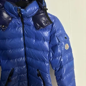 Moncler jacka  - Säljer en blå moncler jacka i  väldigt bra skick. Jackan är i strl 0, passar mig som normalt har S. Köptes från MerchSweden men hittar ej kvittot och kan därför inte registrera koden som visar äktheten, säljer den därför till ett mycket billigt pris
