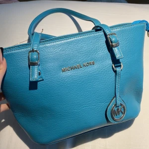 Michael kors - Säljer min michael kors handväska då den inte har kommit till användning men väskans handtag där nere är lite slitet men funkar fortfarande utmärkt! Säljer väskan för 750 men köpte väskan för 2500