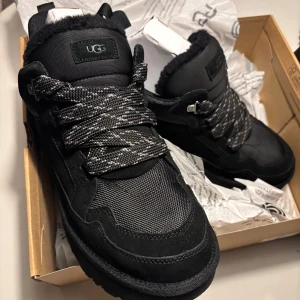 UGG Lowmel sneakers *special edition* - Säljer ett par svarta UGG sneakers - helt nya. Köpta i London. I Butik är nypris 3000kr. De har en robust sula och är fodrade med mjukt material för extra värme. Skorna har snörning och är perfekta för höst och vinter. De är både snygga och bekväma, idealiska för kalla dagar.
