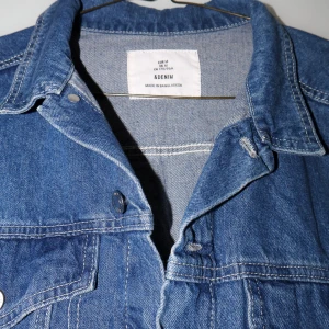Blå jeansjacka  - Säljer en snygg blå jeansjacka i storlek M. Jackan har en klassisk design med knappar framtill och två bröstfickor. Perfekt för vår och sommar! 💙