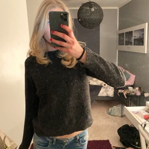 Mörkgrå stickad tröja - Säljer en mysig mörkgrå stickad tröja i bra skick. Perfekt för höst och vinter med sin varma och bekväma passform. Tröjan har långa ärmar och en enkel design som passar till det mesta. Perfekt för en avslappnad stil! 🖤