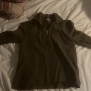 Olivgrön tröja från Sandro - Säljer en snygg olivgrön tröja från Sandro med dragkedja vid halsen. Perfekt för höst och vinter, med långa ärmar och en bekväm passform. Tröjan är i bra skick och passar både till vardags och lite finare tillfällen.