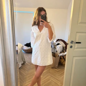 Vit klänning med broderad spets - Säljer en superfin vit klänning från Zara. Använd endast en gång, säljer då den är lite kort för min smak!