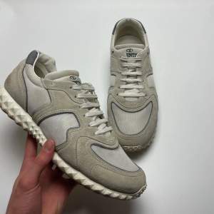 Säljer ett par snygga Valentino Garavani sneakers i beige och grå. De har en cool, mönstrad sula och är gjorda i en mix av mocka och syntetmaterial. Perfekta för både vardag och fest! Skorna har snörning och är i mycket bra skick. 43 passar 44