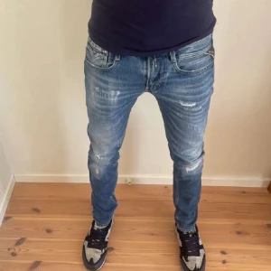 Replay Anbass - Säljer ett par snygga blå jeans med coola slitningar. De har en normal passform och är perfekta för en avslappnad stil. Jeansen har en klassisk femficksdesign och är i bra skick. Perfekta för både vardag och fest! Nypris 1899kr köpta på NK kvitto medföljer. W31 riktigt feta passar till allt🙌🏾