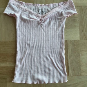 Rosa ribbad topp från BDG Jeans - Säljer en söt rosa ribbad topp från urban outfitter i storlek XS. Toppen har en v-ringad design med spetsdetaljer längs kanten och korta ärmar. Perfekt för sommardagar eller en avslappnad dag ute. Den är i mycket bra skick och redo för en ny ägare! Jag har endast använt den typ 2 gånger💕