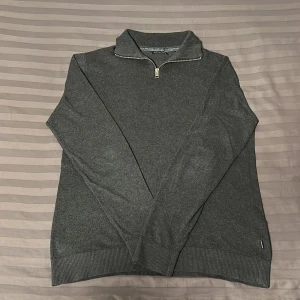 Grå tröja med dragkedja från Jack & Jones - Säljer en stilren grå quarter zip tröja från Jack & Jones i mycket bra skick. Perfekt för både höst och vinter. Passar till både vardag och lite finare tillfällen. Pris kan diskuteras!
