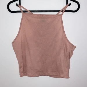 Beige croppad linnetopp - Säljer en superfin beige croppad linnetopp med smala axelband. Perfekt för sommardagar eller som ett lager under en jacka. Toppen är i ett mjukt och bekvämt material, vilket gör den idealisk för både vardag och fest. Passar perfekt till jeans eller kjol!