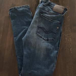 Säljer ett par snygga blå jeans från Replay i modellen Anbass. De har en klassisk femficksdesign och är i storleken 32/32. Hör av er vid frågor!