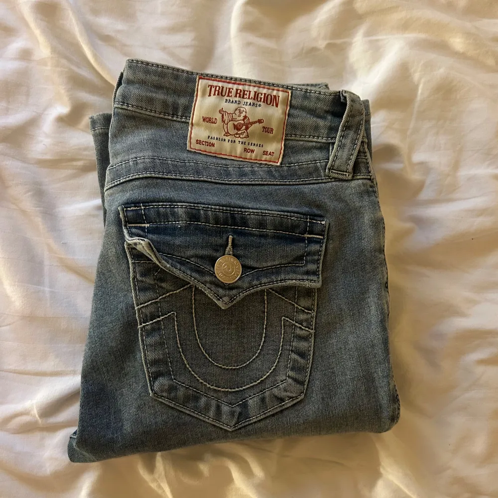 Säljer du dessa as snygga True Religion jeansen. Jensen är ljusblå, Mid Rise Bootcut och storlek 26. Jag är 173 cm, och de sitter perfekt på mig. Jag köpte de i sommras nya för 1200kr, och har använt de ca 5ggr. Säljer för 800kr. De har inga skador, och är i nyskick. Har ej på köpnu, eftersom priset kan ändras. Jeans & Byxor.