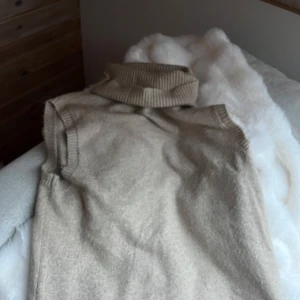 Beige ärmlös polotröja från Soyaconcept - Säljer en superfin beige ärmlös polotröja från Soyaconcept. Perfekt för lager-på-lager under höst och vinter. Den har en mysig ribbad polokrage som ger extra värme och stil. Passar både till vardags och lite finare tillfällen.🤍 