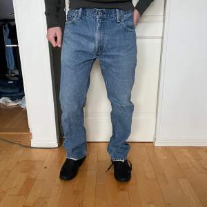 Säljer ett par klassiska Levi's jeans i blå denim. De har en straight passform och är i mycket bra skick. Perfekta för både vardag och fest! Jeansens midja är midwaist och de har den ikoniska Levi's-lappen baktill.