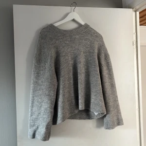 Grå stickad tröja från Gina Tricot - Mysig grå stickad tröja från Gina Tricot i storlek S. Perfekt för kyliga dagar med sin lösa passform och långa ärmar. Den har en klassisk rund hals och ribbade kanter som ger en stilren look. Passar både till vardags och mysiga hemmakvällar. 🧶