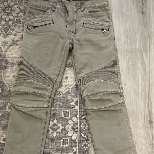 Hel gråa balmain jeans  - Säljer ett par grå Balmain-byxor i mycket bra skick knappt använda. coola detaljer med dragkedjor. 34 längd 28 - 29  midja