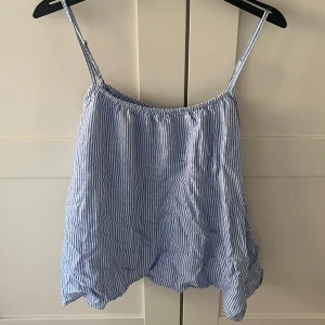 Linne från H&M - Säljer en supersöt blå- och vitrandig linnetopp från H&M. Toppen är du bra skick och passar perfekt för varma sommardagar!💙