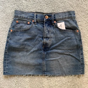 Jeanskjol från lager 157 - Säljer en snygg jeanskjol från Lager 157 i storlek XS. Kjolen är i en klassisk blå färg, perfekt för både vardag och fest!