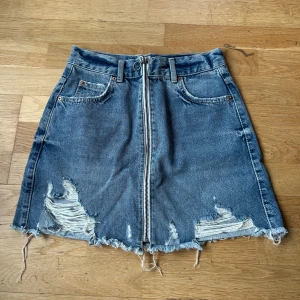 Jeanskjol från Gina Tricot - Säljer en cool jeanskjol från Gina Tricot i storlek 34. Kjolen har en snygg dragkedja framtill och slitna detaljer för en trendig look. bomull, så du kan känna dig bra medan du ser bra ut! 🦋endast använd 2 gånger så toppen skick!