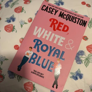 Red, White & Royal Blue - Säljer boken 'Red, White & Royal Blue' av Casey McQuiston. Boken handlar om kärlek mellan Amerikas första son och en prins av Wales. Perfekt för dig som gillar romantik och humor!