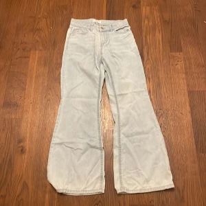 Ljusblå bootcut jeans från Lindex - Säljer ett par ljusblå byxor från Lindex i storlek 152.De är lite stora i storleken så den kommer också passa 158-164. De har en bootcut-stil som ger en snygg siluett. Perfekta för både vardag och festliga tillfällen. Byxorna är i bra skick och redo för en ny ägare!