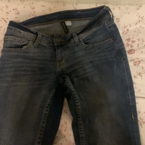 Blå jeans med bootcut - Säljer ett par snygga blå jeans med bootcut-stil. De har en klassisk femficksdesign och är i bra skick. Perfekta för både vardag och fest! Passar till allt från sneakers till klackar.