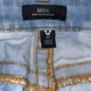 Ljusblå bootcut jeans från True Religion - Snygga ljusblå bootcut jeans från True Religion med slitna detaljer. De har klassiska femficksdesign. Perfekta för en avslappnad stil. Köpt begagnat men personligen aldrig använd. Perfekta till skolan och nu mot våren!💞