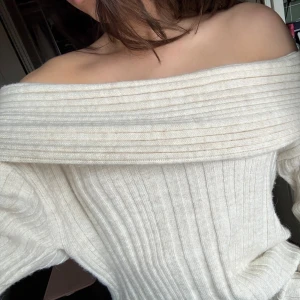Vit ribbad offshoulder tröja från NA-KD - Säljer en stilren vit ribbad offshoulder tröja från NA-KD. Perfekt för en trendig look med sin bekväma passform och långa ärmar. Passar utmärkt till jeans eller kjol för en avslappnad stil. Hör av dig vid intresse! 🤍
