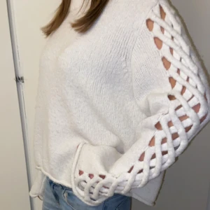 Vit stickad tröja med flätade detaljer - Säljer en vit stickad tröja med unika flätade detaljer längs ärmarna. Pris kan diskuteras💘