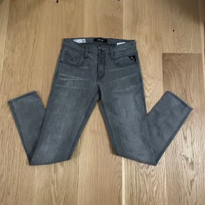 Grå och mörkblå jeansbyxor - Två par jeansbyxor, ett i grått och ett i mörkblått. 