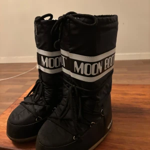 Svarta Moon Boots - Säljer ett par klassiska svarta Moon Boots i stl 35-38! Har ett ”hål” vid framsidan på ena sulan, något som säkert en skomakare enkelt fixar! Men där av priset! ✨💖💕♥️