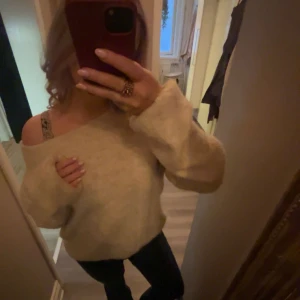 Beige stickad tröja - Mysig beige stickad tröja med en loose passform. Tröjan har långa ärmar och en avslappnad stil, perfekt för kyligare dagar. Den är enkel att matcha med olika outfits.