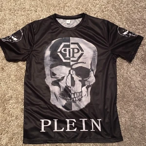 Philipp Plein T-shirt  - Cool svart t-shirt från Plein med stort dödskalletryck på både fram- och baksida. Material påminner om tränings tröja.                                                                                       Har ingen philipp plein tag                                                        Sitter större i storleken 