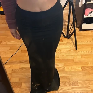 Svart långkjol - Snygg svart långkjol med en tight passform som framhäver figuren. Har bara bara testat den anars helt ny i storlek xs-s💘