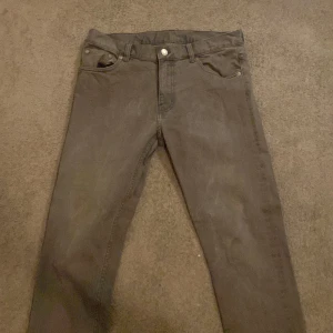 Grå jeans från Weekday - Snygga grå jeans från Weekday i modellen 'Friday Grey'. De har en klassisk femficksdesign och en knappgylf. Perfekta för en stilren look.