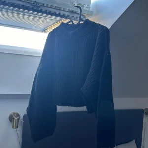 Svart stickad tröja från Gina Tricot - Säljer en svart stickad tröja från Gina Tricot. Tröjan har en croppad design med långa ärmar och en rund halsringning. 💗