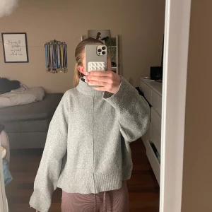 Grå stickad tröja från Stories - Säljer en grå stickad tröja från Stories i storlek XS, för att den inte kommer till användning längre . Tröjan har en hög krage och långa ärmar med ribbade muddar.💓