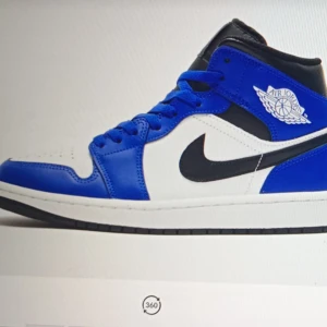 Nike Air Jordans i blått och vitt - Snygga Nike Air Jordans i en fräsch blå och vit färgkombination med svarta detaljer. Skorna har den klassiska Air Jordan-loggan på sidan och en bekväm snörning framtill. Perfekta för att ge din stil ett sportigt lyft.