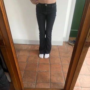 Svarta bootcut jeans - Snygga svarta bootcut jeans med låg midja. Perfekta för en avslappnad stil. De har klassiska femfickor och en knappgylf.  Andvänt en gång och köpt i pack, exakt samma fast i ljusblå finns på min profil för försäljning! Midjemått: 34 mycket stretchiga Innerbenslängd: 68
